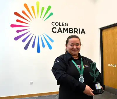 Coleg Cambria and Iâl Restaurant learner Victoria Royer shows off her prize.