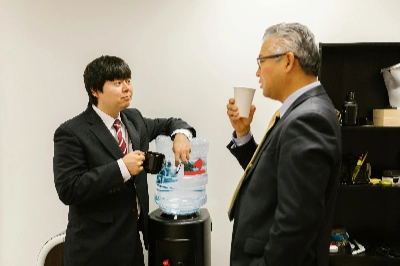 Work colleagues talking around a water cooler
