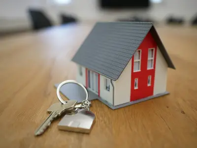 Tiny model house with a house key next to it - Things to Do Once You’re a Homeowner 