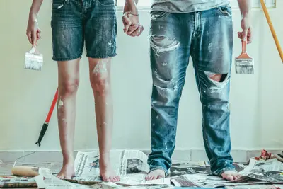 Young couple hold hands in the middle of a DIY session - Why It’s Never Too Late to Start Routine Maintenance on Your Home