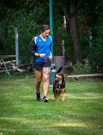 a woman jogging with her dog on a lead