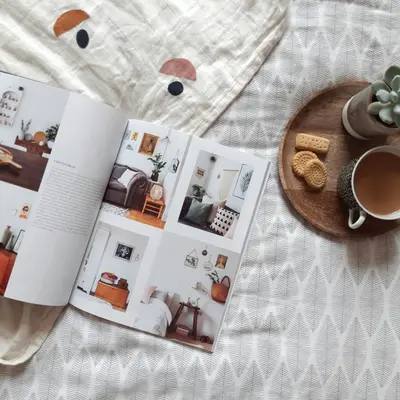 Home decor magazine lying open on a soft, inviting bed - The Little Home Changes That Make Everyday Living Feel Softer