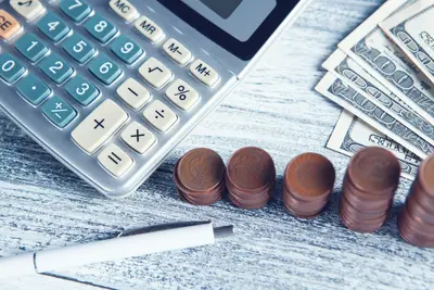 Image of calculator with coins and dollar bills - Making Smarter Financial Decisions With the Assets You Already Own