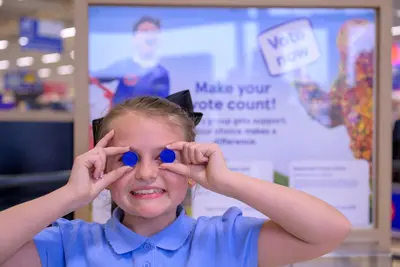 Kids pose with Tesco Wrexham staff as part of the blue token initiative - Vote For Wrexham Schools With Tesco Tokens