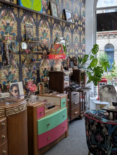 Interior of Eyecadia with patterned wallpaper and vintage furniture – Eyecadia: Bespoke Eyewear, Styling and Colour Analysis in Wrexham