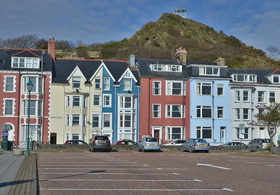 Colourful terraced seafront houses in Aberdyfi below a rocky hill – The Aberdyfi Guide Review: Six Walks Through Aberdyfi’s Hidden History