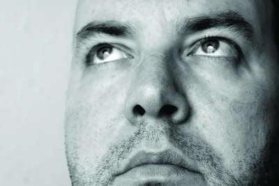 Black and white close-up of a man’s face looking upwards – Do You Know? 20 Facts That Sound Made Up… But Are True