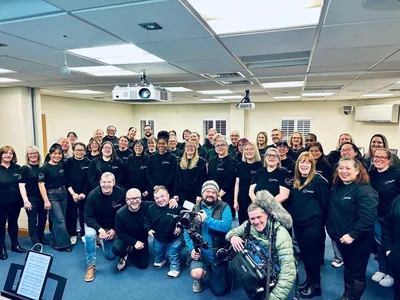 Members of the Welsh Healthcare Choir smiling together at a rehearsal